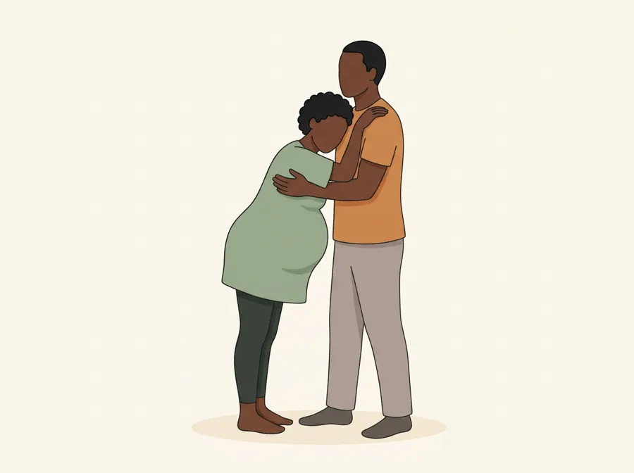 She leans her weight forward onto her standing partner, who holds her through the contraction.